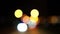 Bokeh car lights in the evening city. Defocused headlights and street lighting at night. Moving bokeh circles of cars at