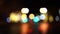 Bokeh car lights in the evening city. Defocused headlights and street lighting at night. Moving bokeh circles of cars at