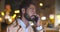 Bokeh shot of young man talking on smartphone outdoors at night