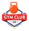 Bold gym club logo featuring a kettlebell above a vibrant red banner. Athletic emblem for fitness center establishment