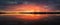 Bold sunset panorama over Delia lake, Moldova. Cloudy dusk sky and red sunlight reflection on the water surface. Dramatic dusk