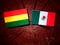 Bolivian flag with Mexican flag on a tree stump isolated