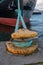 Bollard with mooring ropes at the pier. The ship is moored. The bow of the ship