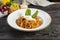 Bolognese pasta with cheese and herbs. A hot main course of spaghetti, minced meat, tomato paste, parmesan cheese and basil