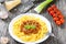 Bolognese ragout with italian pasta on a white plate, decorated with basil leaves, authentic recipe, wooden background with celery