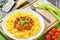 Bolognese ragout with italian pasta on a white plate, decorated with basil leaves, authentic recipe, wooden background with celery