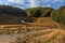 Bolshoye Khmelevskoye mountain lake surrounded with autumn Caucasus mountain forest at sunset. Beautiful scenic blue sky landscape