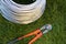 Bolt cutter near the coil wire on the grass. Tool, technology