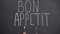 Bon appetit phrase on french written, female holding fork and knife, top view