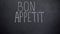 Bon Appetit phrase written on blackboard, high-end restaurant advertisement