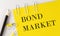 BOND MARKET word on the yellow paper with office tools on white background