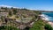 Bondi to Coogee coastal walk pathway with people and Waverley seaside cemetery in Sydney NSW Australia