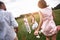 Bonding. family of four running on a grassy field back view clos