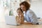Bonding mother and daughter watch video on laptop at kitchen