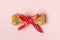 Bone for dogs with red bow isolated on pink background Top view Flat lay Delicious treat for your beloved pet Food for animals