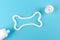 A bone from white toothpaste, animal teeth care concept, on blue background