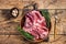 Boneless raw mutton Lamb Shoulder meat in wooden plate with herbs. wooden background. Top view