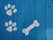 Bones and paws print on blue wood boards background