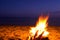 Bonfire. Small campfire with gentle flames beside a lake during a glowing sunset. San Juan night on the beach.