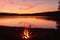 Bonfire. Small campfire with gentle flames beside a lake during a glowing sunset. San Juan night on the beach.