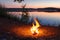 Bonfire. Small campfire with gentle flames beside a lake during a glowing sunset. San Juan night on the beach.