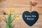 Bonne fete maman, French mothers day card, wood planks with daffodils and a blackboard in shape of a heart