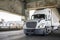 Bonnet powerful big rig semi truck with high cab transporting cargo driving on the two level arched Fremont bridge across