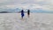 Bonneville - Rear view of couple holding hands standing on Bonneville Salt Flats in Wendover, Western Utah, USA