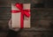 Bonus human man hand give a present Brown Gift box bow tie Red ribbon On old wood floor top view merry christmas and happy new