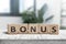 Bonus reward sign on a white table in a bright office