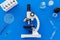 Bood testing with microscope in laboratory. Equipment on blue background top view