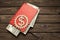 Book, American dollars, gear on a wooden background.