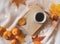 Book, coffee, golden leaves, oranges, pumpkin and lights on a white sweater