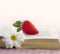 Book with a daisy flower and red strawberry