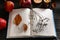 Book with dried flower as bookmark and ripe apples on wooden table