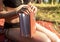 Book in female hand of woman in swimwear on blanket in nature on summer holidays