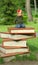 Book festival in the public park, toddler girl sitting on a giant pile of books