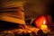 Book, glasses, fruits, a burning candle and autumn leaves on a wooden table.