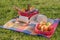 Book, hat and basket of ripe fruits and food