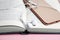 Book, headphones and smartphone on pink background