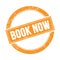 BOOK NOW text on orange grungy round stamp