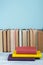 Book stacking. Open book, hardback books on wooden table and blue background. Back to school. Copy space for text