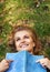 Books can really get your mind going. Shot of an attractive young woman reading a book while lying outside on the grass.