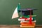 Books, diploma, academic cap and irish flag on wooden surface