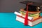 Books, diploma and graduation cap with tassel on blue with copy space