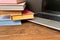 Books and laptop on wooden table. The concept of learning from b