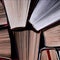 Books. Lots of colourful thick open books stand on a dark background