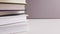 Books pile different colors close up on white gray background and frame move away from books Education study school learning