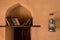 Books on a shelf in a arch window of old arabian castle. Oil lamp hanging next to the window.