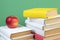 Books stacking. Books on wooden table and green background. Back to school. Copy space for ad text